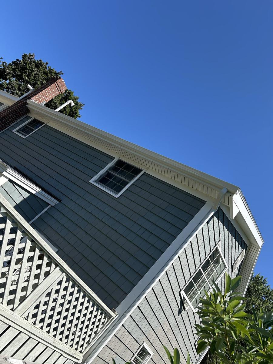 Seamless white gutter and fascia detail on a shingled home